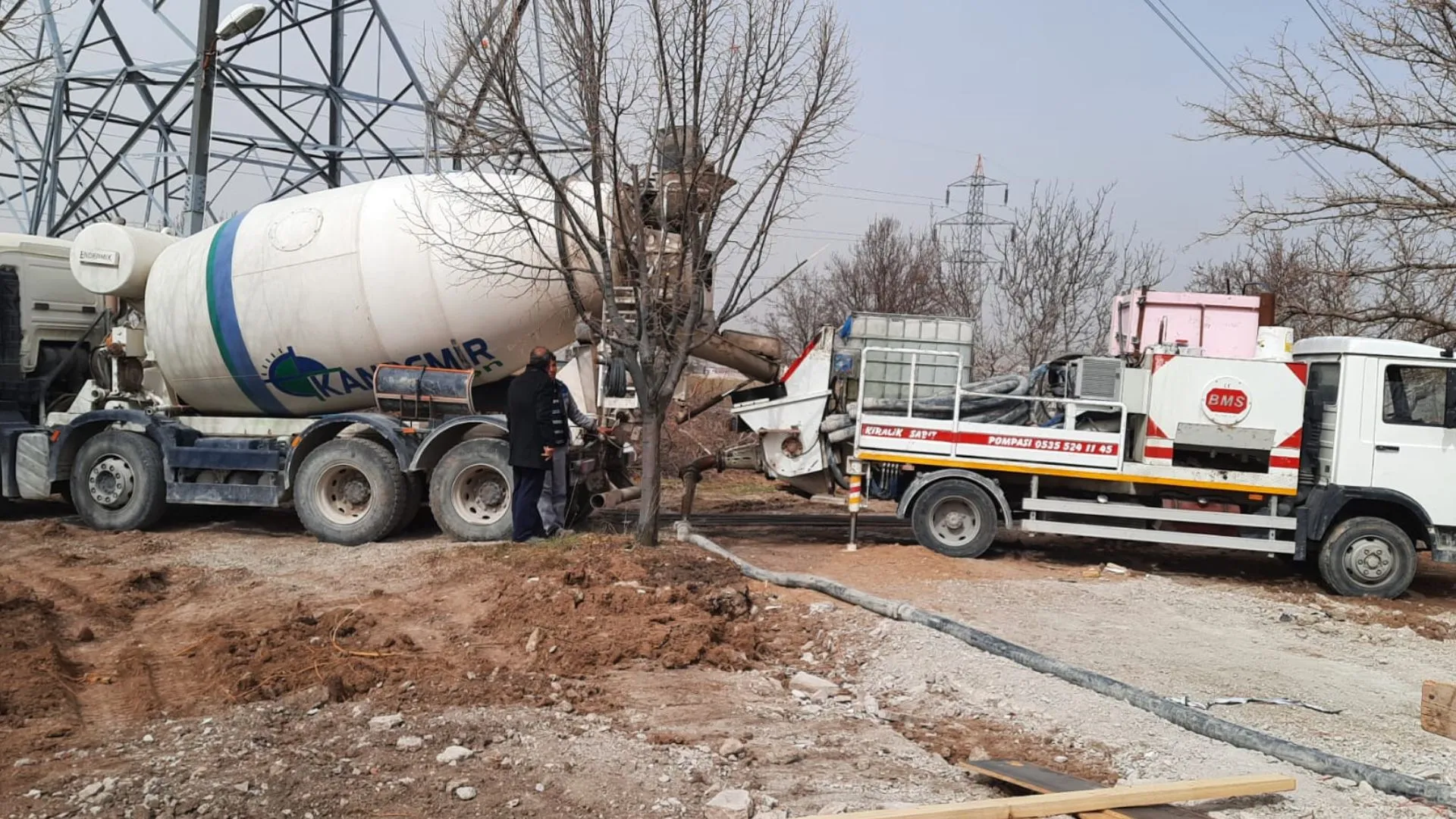 Dar bir sokakta bina önüne kurulmuş yer pompası ve bina içine uzanan beton boru hattı