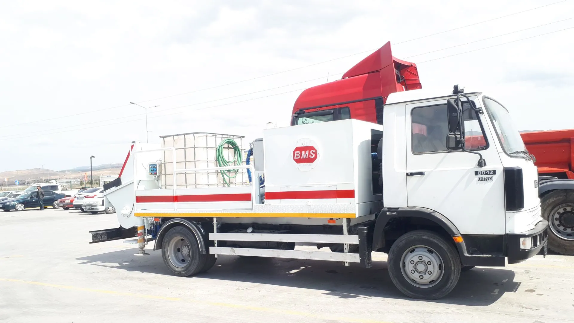 Şantiyede çalışan kamyon üzerine monteli sabit beton pompası ve operatörü